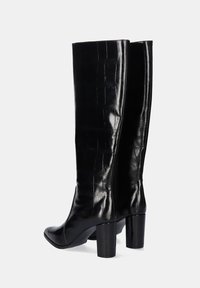 Botas negras hasta la rodilla con un acabado de cuero grabado en cocodrilo brillante, tacones en bloque y un diseño de punta afinada.
