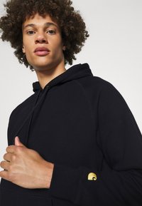 Carhartt WIP HOODED CHASE - Jersey con capucha - dark navy/gold