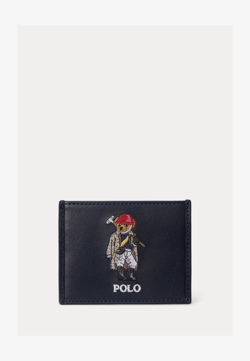 Tmavomodrá kožená peňaženka vyšívaná obrázkom medveďa, ktorý má na sebe pólo výstroj a prilbu, drží palicu a pod ním je text "POLO".
