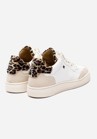 Sneakers bianchi a basso profilo con accenti beige, stampa leopardata sulla parte posteriore e sul colletto, chiusura con lacci frontale e una piccola croce nera ricamata di lato.