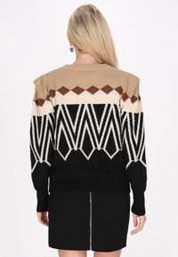 Pulover din tricot cu un model geometric în culorile maro, bej, negru și crem. Include o margine ribbată și un design etanș.