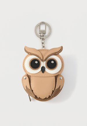 Suport pentru breloc în formă de bufniță, realizat din piele sintetică de culoare cărămizie, cu ochi mari albi cu centru negru, accesorii argintii și cusături detaliate.