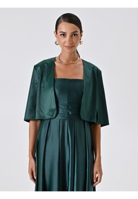 Abito in satin verde smeraldo con maniche corte e strutturate e un corsetto aderente. Presenta pieghe lungo la gonna e una texture liscia e lucida.