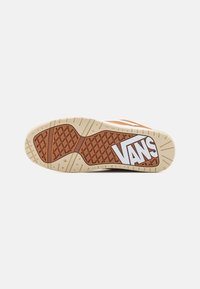 Vans sneakersålen med en strukturert gummioverflate, i en brun og kremfarget fargekombinasjon med en fremtredende hvit logo.