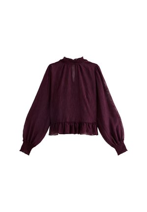Blusa burdeos con mangas largas, escote con volantes y dobladillo. Hecha de una tela ligera con acabado texturizado y puños fruncidos.