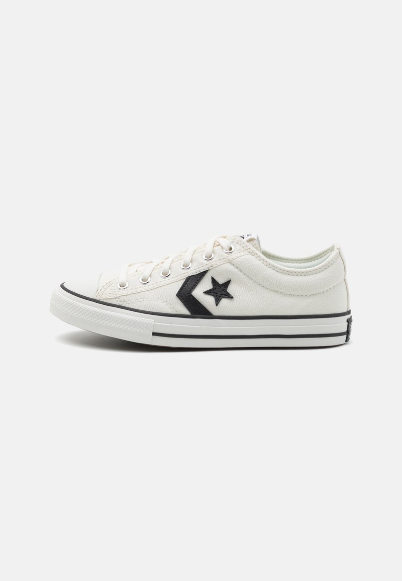 Weißes Canvas-Sneaker mit schwarzen Akzenten, ausgestattet mit einem Stern-Logo, runder Zehenpartie und schwarzer Gummisohle. Schnürdesign mit Metallösen.