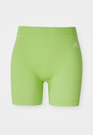 Žalios sportinės šortai, pagaminti iš tempimo audinio, su vidutinio aukščio juosmeniu ir Adidas logotipu priekyje, dešinėje pusėje.