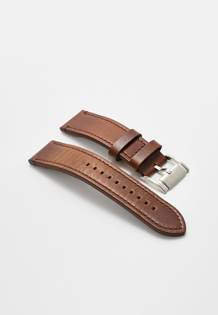 Cinturino in pelle marrone con fibbia in metallo argento, con cuciture sottili e diversi fori per una regolazione della misura. Texture liscia.