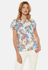 Top a maniche corte con un vivace motivo floreale e di uccelli in rosa, blu e verde su uno sfondo azzurro chiaro. Tessuto morbido con maniche arricciate.