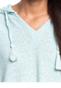 Helles blaues Kapuzensweatshirt mit V-Ausschnitt, aus weichem Stoff, mit Quastenakzenten an der Kordel. Weicher Textil mit lockerer Passform.