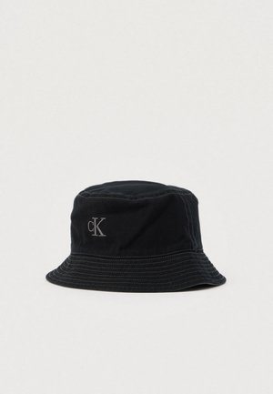 Schwarzer Baumwoll-Bucket-Hut mit leicht gerundetem Kopfteil, steifem Rand und einem dezenten grauen Bestickten Logo an der Seite.