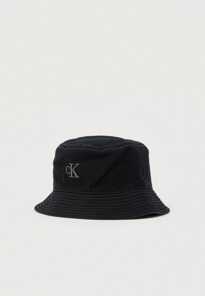 Μαύρο βαμβακερό καπέλο τύπου bucket με ελαφρώς στρογγυλεμένη κορυφή, σκληρό γείσο και διακριτικό κεντημένο λογότυπο σε γκρι χρώμα στο πλάι.