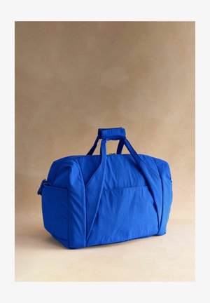 Niebieska torba typu duffel wykonana z lekkiego materiału, z podwójnymi uchwytami, zamkiem błyskawicznym i przednią kieszenią. Gładka faktura, kompaktowy prostokątny kształt.