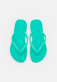 Turkosa flip-flops med strukturerad fotbädd och tunna remmar. Har en logotyp och ett mönstrat accent på remmen. Tillverkade av hållbar gummi.
