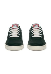 Pár tmavozelených tenisiek Reebok s bielymi šnúrkami a odtieňom bielej podrážky, zobrazené spredu na bielom pozadí.