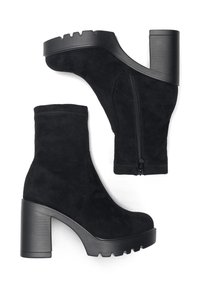 Melnas zamšādas potīšu zābaki ar masīlu papēdi, ar sānu rāvējslēdzēju, teksturētu zoli un gludu augšdaļu. Dizains piedāvā moderno siluetu.