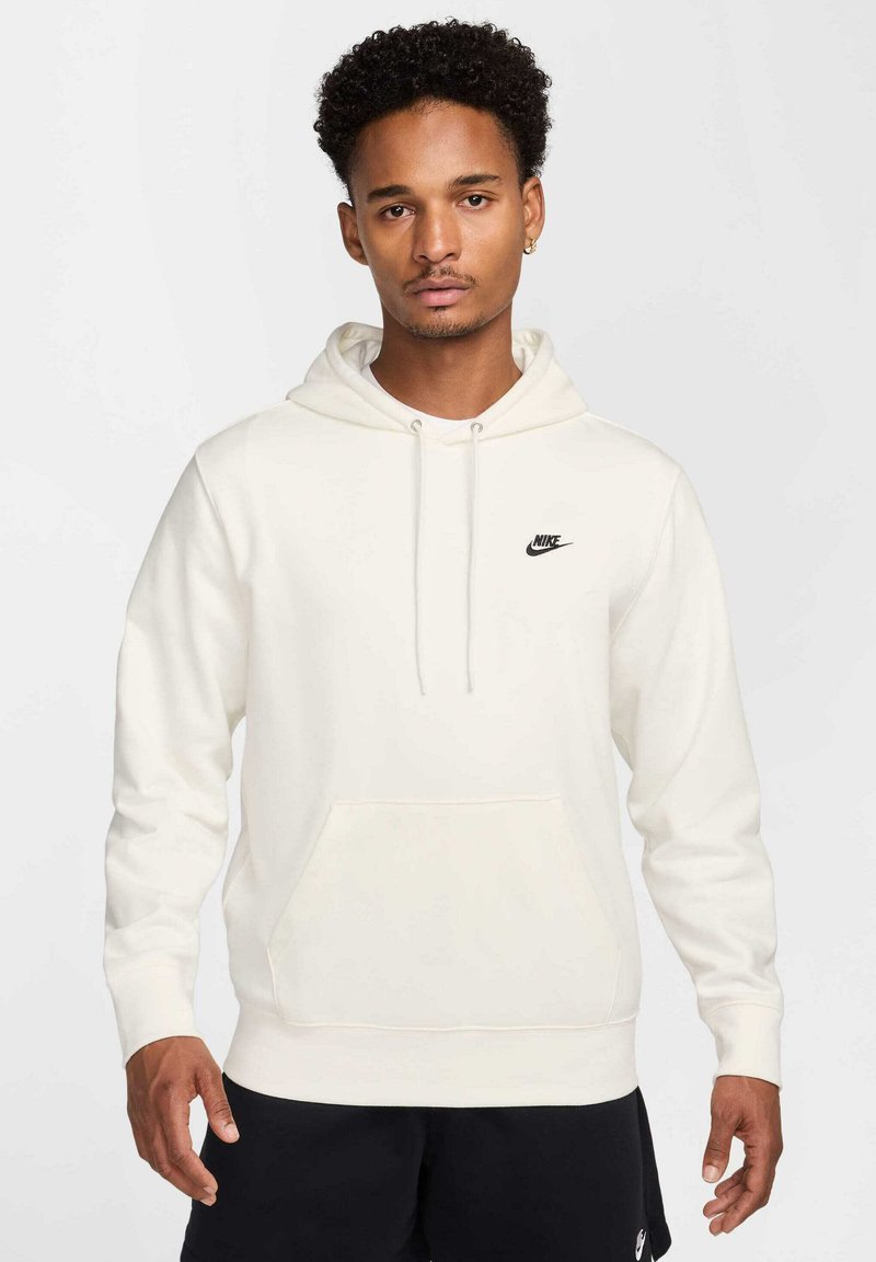 Felpa crema con tasca frontale, cappuccio regolabile con cordino e logo Nike nero sul petto. Presenta polsini e orlo a coste.