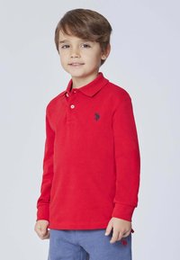 Polo a maniche lunghe rossa in cotone, con colletto, due bottoni e un piccolo logo nero sul lato sinistro del petto.