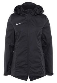 Zwarte geïsoleerde jas met een rits aan de voorkant, capuchon en een wit Nike-logo op de borst. Heeft een gladde, matte textuur en verstelbare manchetten.