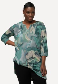 Losse tuniek top in tinten van teal en groen, met een aquarelachtig patroon, driekwartmouwen en een V-hals ontwerp.