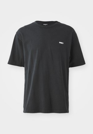T-shirt noir à manches courtes en coton, doté d'un col rond et d'un petit logo blanc "OBEY" sur la poitrine.