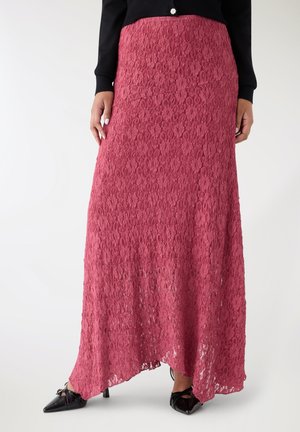 Gonna lunga in pizzo bordeaux strutturato, con vita aderente e silhouette fluida, abbinata a décolleté nere con punta affilata.