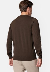 Brązowy sweter dziany z długimi rękawami, ściągaczami przy nadgarstkach i u dołu, z okrągłym dekoltem oraz gładkim, strukturalnym materiałem.