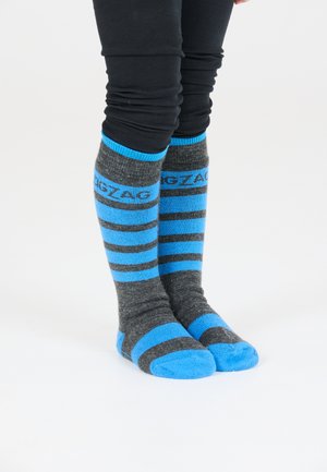 Grau- und blau gestreifte Socken mit einem gerippten Bündchen, das eine einfarbige blaue Zehenkappe und ein Zickzackmuster oben aufweist.