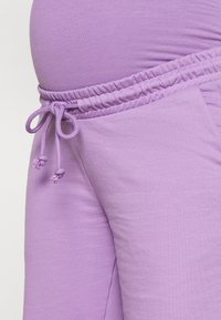 Jogging en violet en mélange de coton doux avec une taille élastique, un cordon de serrage réglable et des poches latérales pour plus de commodité.