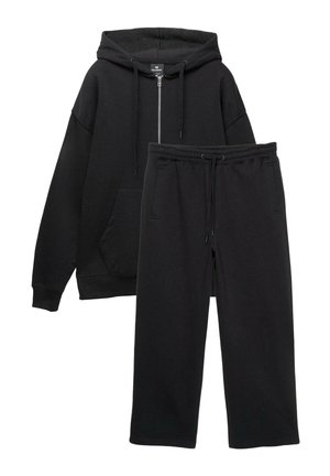 Felpa nera con zip, grande tasca frontale e polsini a costine abbinata a pantaloni jogger neri con vita elasticizzata e tasche laterali.