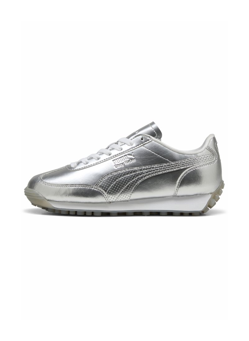 Sneaker argentata con una parte superiore metallica elegante, caratterizzata da un design con lacci, accenti texturizzati e una suola piatta in gomma con piccoli borchie.