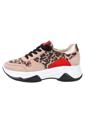 Les baskets présentent un design à imprimé léopard, un matériau en daim beige, des lacets noirs, des accents rouges et métalliques, ainsi qu'une semelle épaisse blanche et noire.