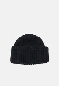 Crna pletena kapa s rebrastom teksturom i savijenim rubom. Materijal izgleda mekano i gusto, pogodno za hladno vrijeme.