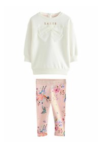 Sweatshirt blanc avec un nœud et le texte doré "BAKER", accompagné de leggings roses avec un motif floral et des oiseaux. Mélange de coton doux.