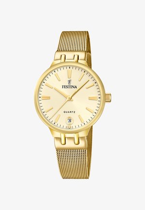 Zelta kvarca pulkstenis ar sietiņu, apaļu korpusu un gaiši zeltītu ciparnīcu. Iespējas ietver stundu marķējumus, datuma displeju un vainagu.