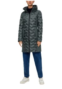 Gevoerde donkergroene jas met rits aan de voorkant en capuchon, voorzien van een gewatteerde textuur en zijzakken, gedragen over blauwe denimbroek en witte sneakers.