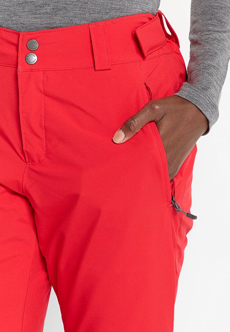 Pantaloni rossi con una texture liscia, due bottoni in vita, tasca laterale con cerniera e passanti per cintura. Presentano un design aderente.