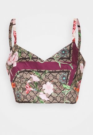 Crop-top med blomstermønster og tynde stropper, med pink, orange og grønne blomster på en vinrød og beige geometrisk baggrund.