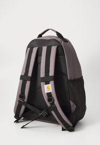 Gray and black fabric backpack with padded back, adjustable black straps, mesh side pockets, and embroidered logo patch on front.
