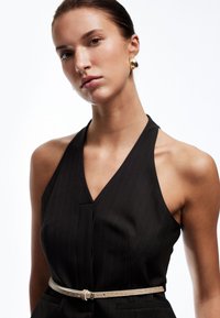 Schwarzes Pinselstreifen-Halterkleid mit tiefem V-Ausschnitt, ausgestattet mit einem hellbeige strukturierten Gürtel. Glattes Material und taillierte Passform, mit Taschen.