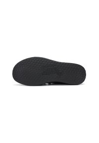 Black rubber shoe sole with a textured grip pattern and embossed logo. Smooth edges and flat design for comfort and stability.