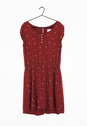 Červené šaty s krátkým rukávem s malým bílým vzorem paisley a puntíky, kulatý výstřih, knoflíková léga, elastický pas, zavěšené na černém ramínku.