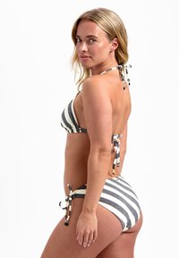 Gestreiftes Bikini-Set mit einem Halterneck-Oberteil und seitlichen Bindebändern. Die Farben sind Schwarz, Weiß und Beige, mit einem strukturierten Stoff.