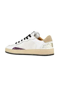 Sneaker bianca con lacci neri, suola beige, dettaglio in glitter viola vicino alla punta e motivo screpolato con scritte dorate sul tallone.