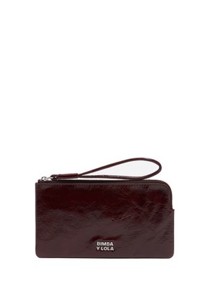 Burgundowa skórzana portmonetka o teksturowanym wykończeniu, z paskiem na nadgarstek i srebrnym akcentem z logo. Zamek błyskawiczny wzdłuż górnej krawędzi.