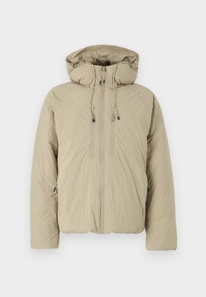 Beige Steppjacke mit Kapuze, ausgestattet mit einem Frontreißverschluss, elastischen Kordeln und Seitentaschen. Hergestellt aus leichtem, strukturiertem Stoff.
