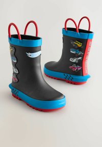 Bottes de pluie en caoutchouc noires avec un bord supérieur bleu, des semelles rouges et des poignées rouges. Présente des graphiques de voitures colorées et des accents à carreaux.