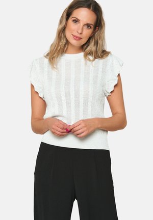 Top bianco lavorato a maglia con maniche corte e dettagli svasati, caratterizzato da un motivo a righe testurizzato. Abbinato a pantaloni neri a gamba larga.