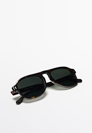 Folded dark tortoiseshell sunglasses with rectangular green tinted lenses on a white background.