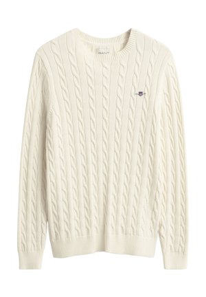 Kreemikas soonikkoes kampsun ümar kaelusega, soonikkoes mansettide ja äärega. Üles vasakul rinnal on väike tikitud logo.